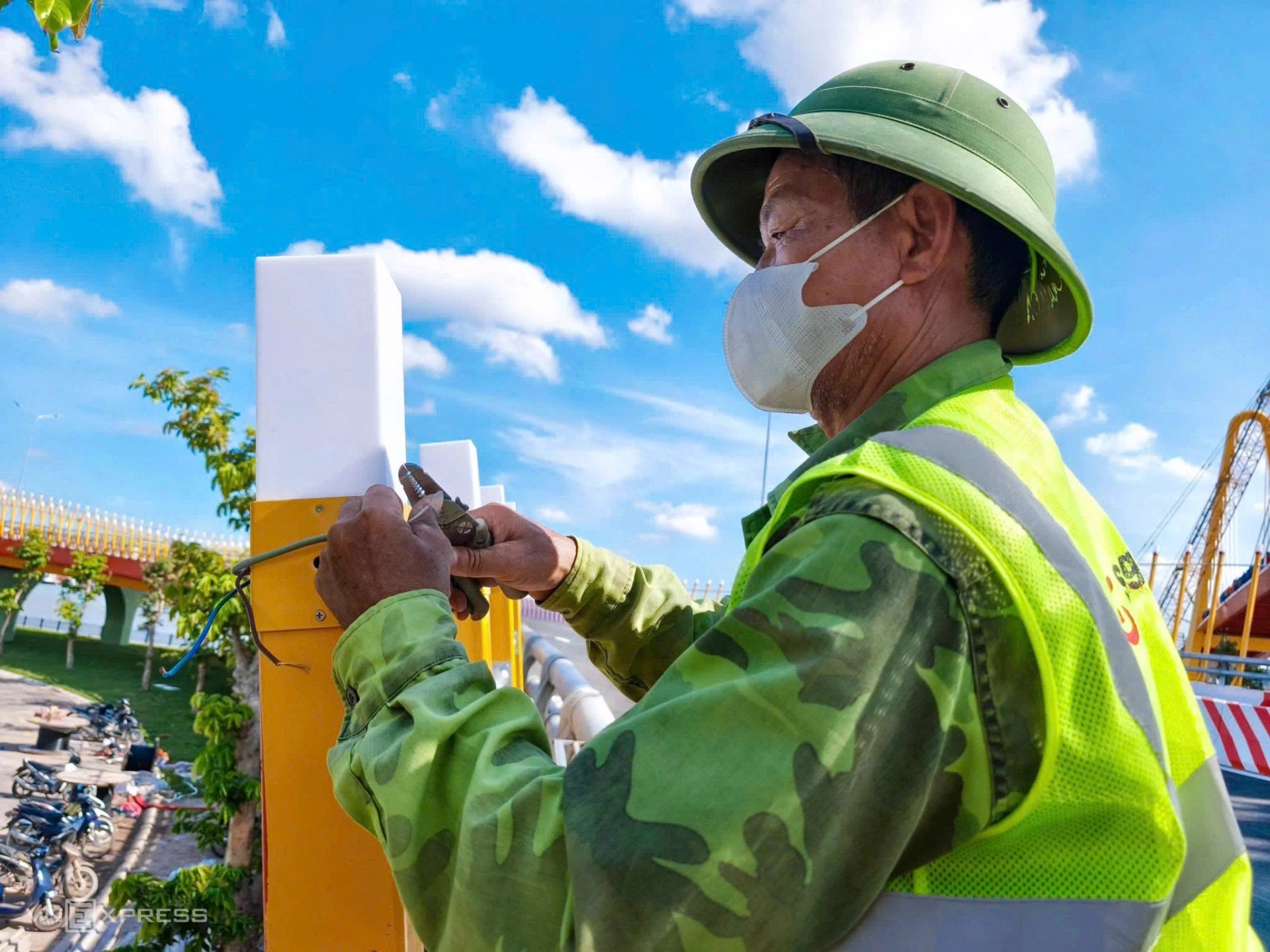Công nhân Nguyễn Văn Bính, 59 tuổi, lắp đèn trang trí trên lan can đường dẫn phía đảo Vũ Yên.
