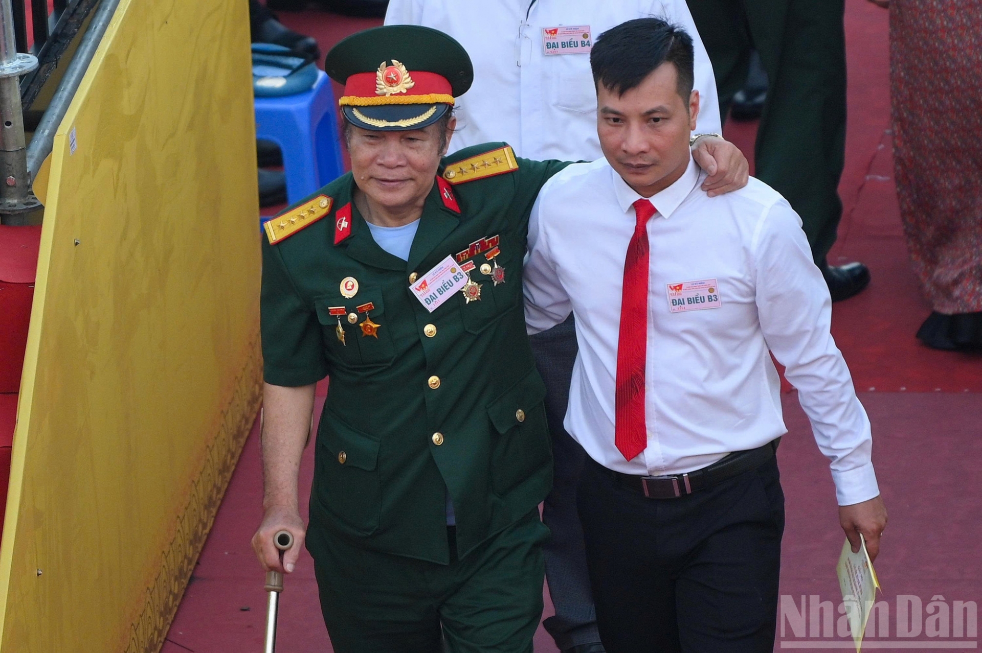 Đi lại khó khăn, một cựu chiến binh được dìu vào khán đài.